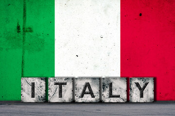 Obraz premium Italy, words on stone blocks, on grunge background of Italy flag, on a concrete wall. Copy space. Signs and symbols.