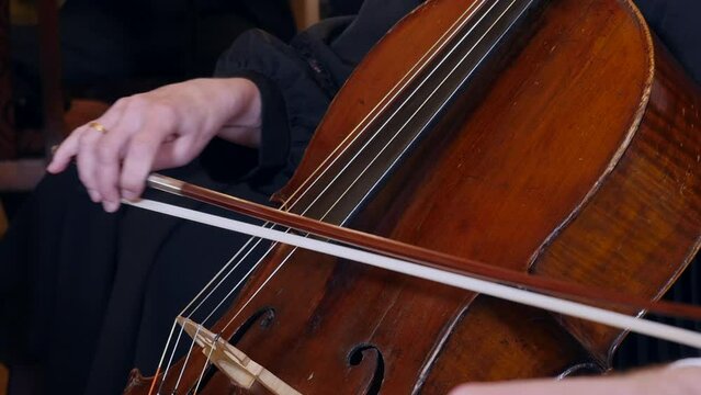 Closeup of female musician performing classical music with cello