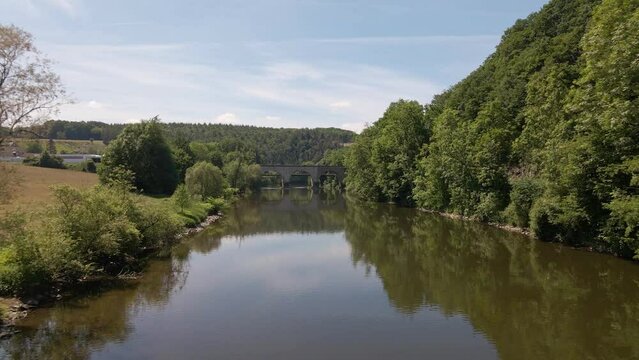 Aerial approach towards an old train trestle that connects the two banks of the Sieg in west Germany on a sunny spring day.