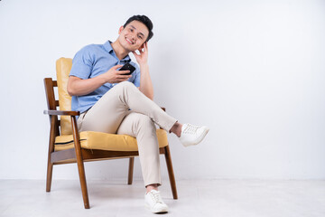 Image of young Asian man sitting on chair