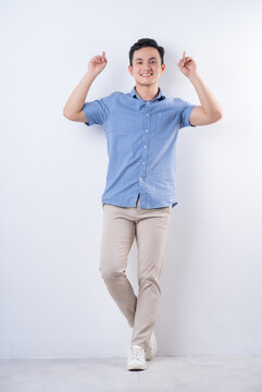 Full length image of young Asian man on white background