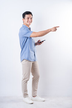 Full length image of young Asian man on white background