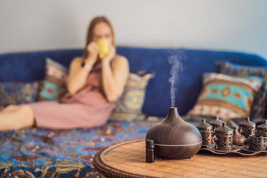 Aromatherapy Concept. Wooden Electric Ultrasonic Essential Oil Aroma Diffuser and Humidifier. Ultrasonic aroma diffuser for home. Woman resting at home