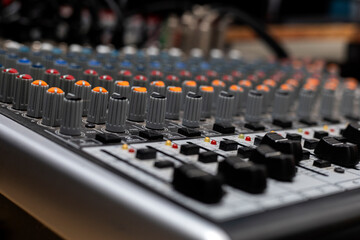 Close-up with selective focus of different knobs and switches of a professional sound console....