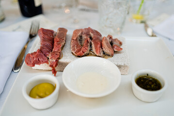 Raw beef fillets served before a hot stone grill to be cooked live.
