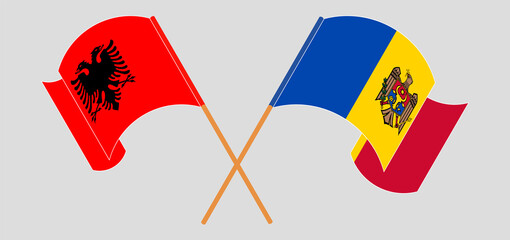 Crossed and waving flags of Albania and Moldova