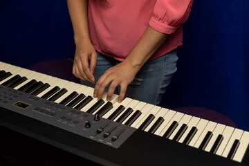 Latin American teacher teaches her student a major chord on a piano keyboard. Concept of music...