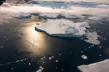 flying tour above Greenland with Icebergs floating on the ocean