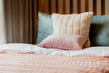 Bed maid-up with clean white pillows and bed sheets in beauty room. Close-up. Lens flair in sunlight.home interior detail design background