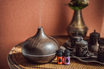 Aroma oil diffuser with aroma oil on table at home. Air freshener