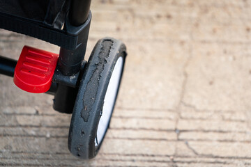 Close-up at a baby stroller wheel with worn out condition on the wheel's surface. Vehicle object...