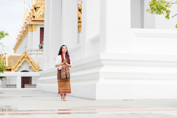 Asia woman wearing traditional dress of Thailand praying in church