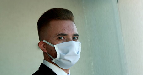 Portrait of man wearing covid-19 face mask prevention against virus pandemic looking at camera