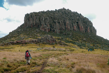 Fototapeta premium Rear view of a group of hikers against a mountain background at the Dragons Teeth at Ol Doinyo Lestima Mountain in Aberdares, Kenya
