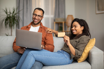 Black Couple Shopping Using Laptop And Credit Card At Home