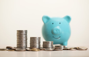 a pile of coins and a green piggy bank on the table, for saving money wealth, and financial...