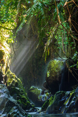 Indonesian stone tunnel waterfall in tropical forest