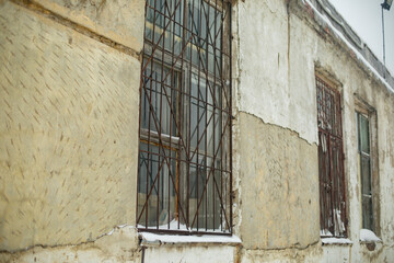Fototapeta na wymiar Window with grille. Old building. Steel bars on window.