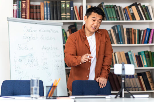 Asian Tutor Teaching Online Video Calling Via Smartphone In Classroom