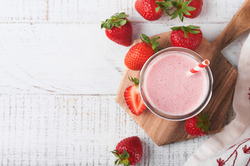 Strawberry smoothie. Vegan smoothie or milkshake from strawberry, banana and mint on white wooden table background. Clean eating, alkaline diet. Top view. Mock up.