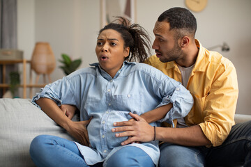 Pregnant Black Lady Having Labor Pains Sitting With Husband Indoor