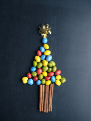 Chocolate peanuts as Christmas tree shape on a blackboard