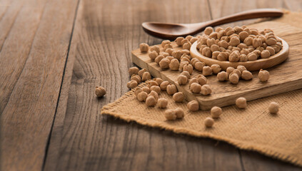 Garbanzo grains on the cutting board on the wooden table.