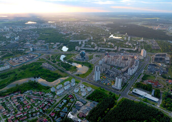 River in city on sunset, aerial view. Suburb houses and multi-storey residential buildings near river in Minsk, Belarus. Cottages and wooden suburb house. Suburban house on sunset panarama, drone view