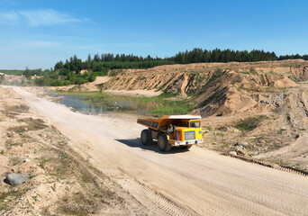 Mining excavator loads sand into dump truck. Excavator loads sand rock into a haul truck. Sand pit development. Mining industry. Electric rope shovel dropping rock ore. Sand mining in opencast.