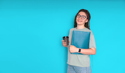 A beautiful young woman with a folder and coffee on a blue background. place for text
