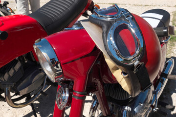 Vintage crash helmet is hanging on the handlebar of a classic oldtimer motorbike. Selected focus.