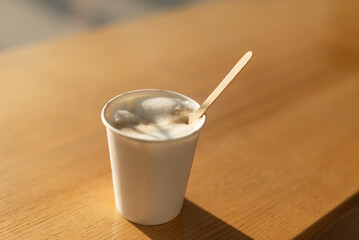 Coffee with milk in a disposable white cup