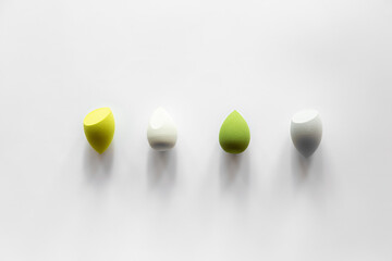 Set of colorful makeup beauty blenders on a white background.