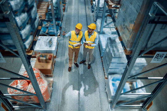 Two employees with tablet at logistics center warehouse