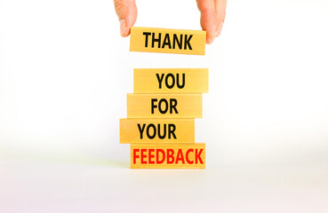 Thank you for feedback symbol. Concept words Thank you for your feedback on wooden blocks on a beautiful white table white background. Businessman hand. Business and thank you for feedback concept.