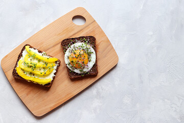 Toasted bread with egg, bell pepper, cream cheese and microgreens on the table. Tasty breakfast. Healthy lifestyle. Top view