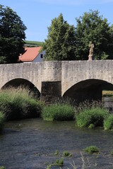 Fototapeta na wymiar historische alte Brücke über die Tauber in Tauberrettersheim Tauberfranken 