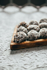 Homemade vegan healthy energy truffle balls with dried apricot, dates, nuts and seeds, covered with coconut flakes. Healthy raw energy bites 