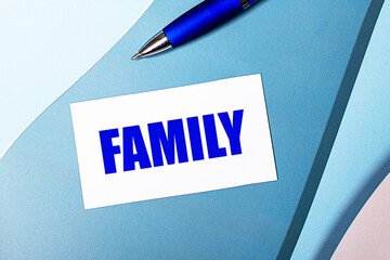 White blank card with FAMILY text and blue pen on blue, cyan and pink background.