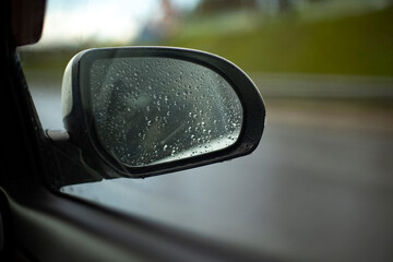 Rear-view mirror in car. Car window in rain. Transport details.