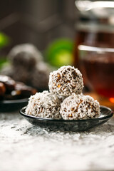 Homemade vegan healthy energy truffle balls with dried apricot, dates, nuts and seeds, covered with coconut flakes. Healthy raw energy bites 