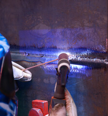 welder hands weld two pieces of metal using argon torch and filler rod, argon welding