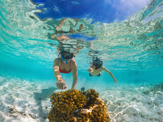 Mother and son discover small fish while snorkeling in Maldives. - obrazy, fototapety, plakaty