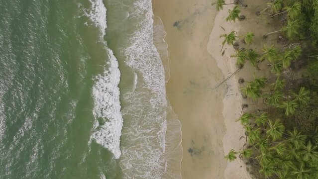 Aerial overhead footage of waves crashing onto the beach in Sierra Leone Africa.