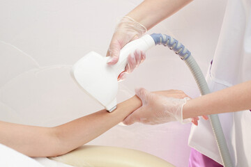 Diode laser hair removal, Beautician removes hair on beautiful female arm, Hair removal for smooth...
