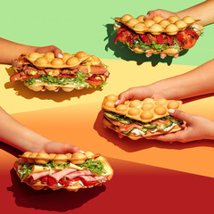 People with food. Hand holding bubble waffle sandwiches with colourful background. Fast food, take away. Snack. Party. Concept.jpg