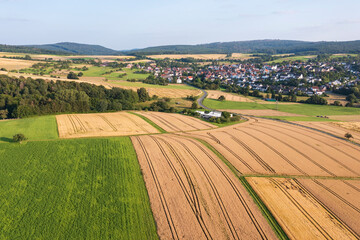 A bird's-eye view of a Taunus landscape with ripe grain fields and a village in the background