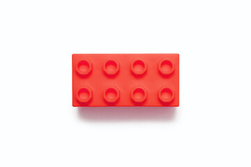 Red plastic detail from the designer on a white background. One detail of the constructor isolated on a white background in the center of the frame close-up