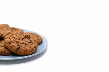 Chocolate chip cookies lie on a plate on a white background with free space for text. Sweet homemade chocolate chip cookies. American style breakfast with chocolate chip cookies