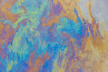 Abstract blurred background of colored stains of gasoline or oil spill on the surface of the water....